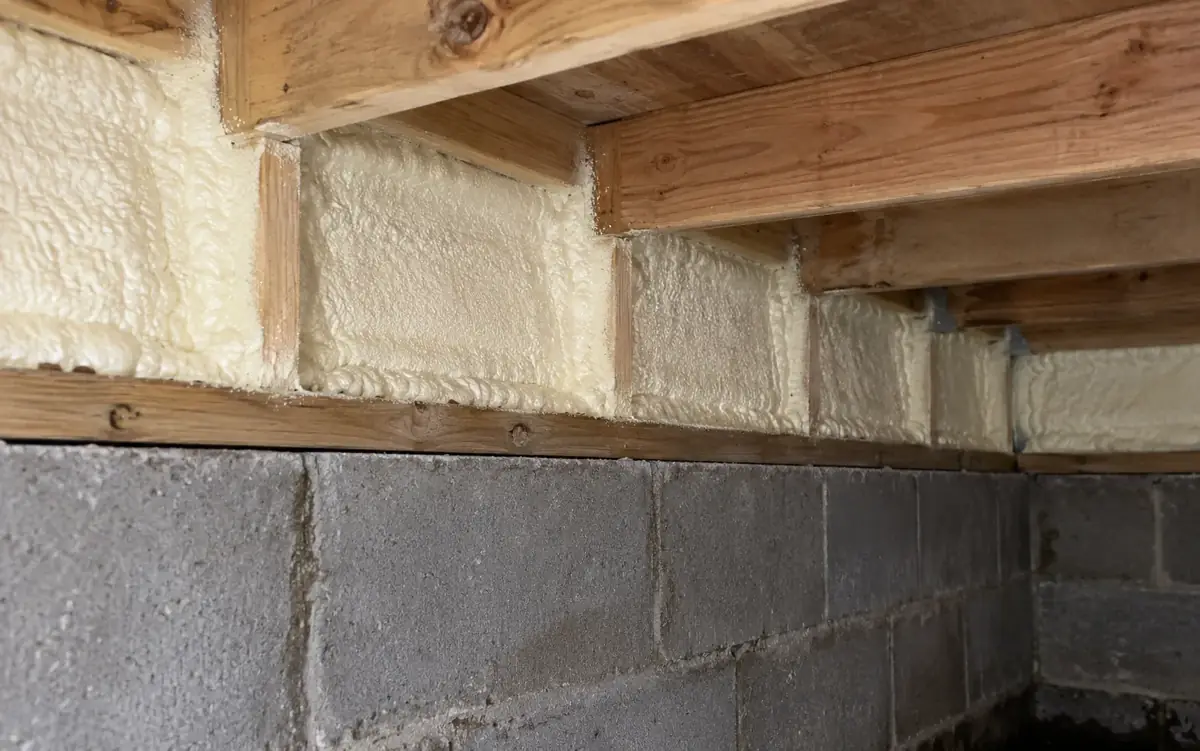 Closed-cell foam sealing the rim joist above a crawl space block wall