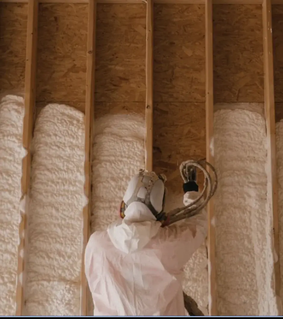 Close view of stud bays sprayed one at a time and trimmed flush to the framing